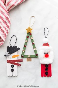 three christmas ornaments are hanging from clothes pins