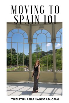 a woman standing in front of windows with the words moving to spain