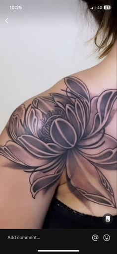 the back of a woman's shoulder with a flower tattoo on it