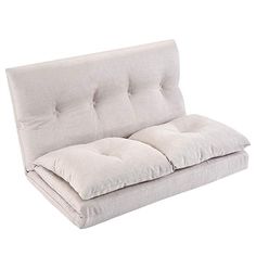 a white futon couch with pillows on it