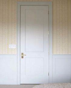 an empty room with two white doors and carpet on the floor