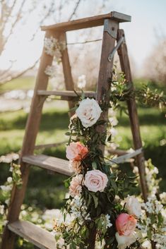 an old wooden ladder decorated with flowers and greenery for a rustic wedding or ceremony