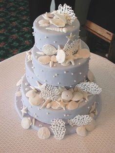 a three tiered cake with seashells on it