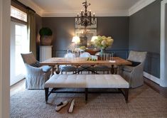 a dining room with a bench and chandelier