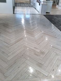 the floor is made up of white marble herringbones and has an interesting pattern