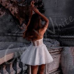 the back of a woman's head wearing a short white dress and high heels