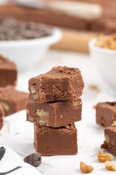 three pieces of chocolate fudge cake stacked on top of each other with nuts around them