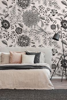 a bed sitting under a black and white wallpaper