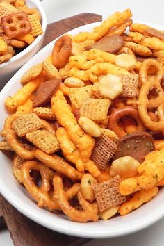 two white bowls filled with cheetos and pretzels