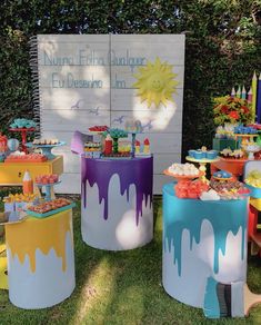 an assortment of colorful desserts on display in front of a sign