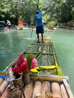 a man standing on top of a bamboo raft