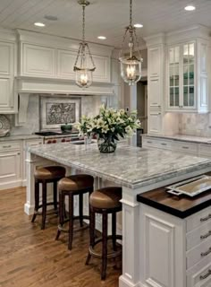 a large kitchen with an island in the middle of it and stools at the end