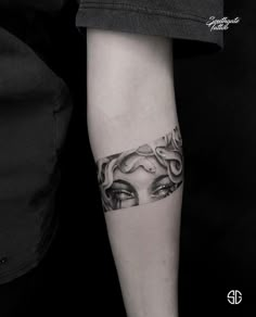 a woman's arm with an eye tattoo on it