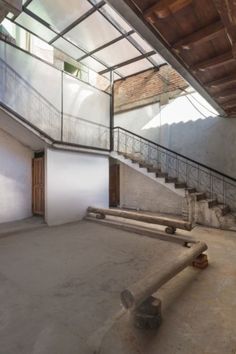 an empty room with stairs and railings in the middle, surrounded by concrete walls