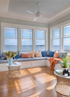 a living room filled with furniture and large windows