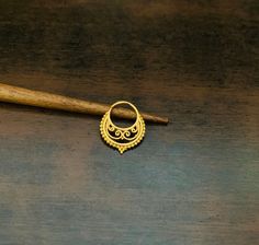 a small gold ring sitting on top of a wooden table next to a baseball bat