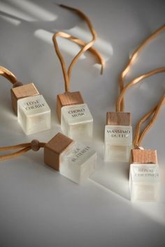 five small wooden cubes tied together with string on white surface, surrounded by gold ribbon