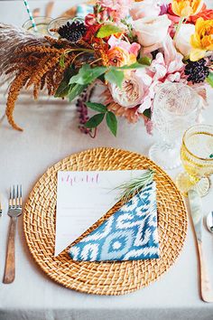 a table setting with place settings, flowers and napkins on the plate next to it