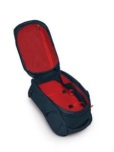 an open suitcase sitting on top of a white floor next to a red object in it