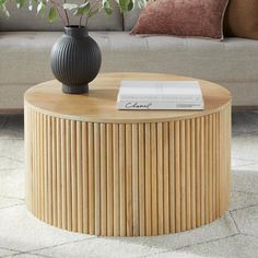 a round wooden table with a book on top