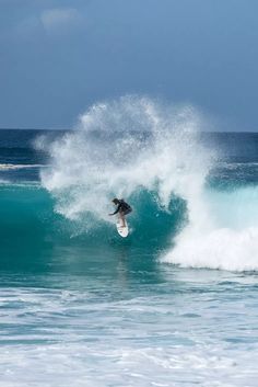 a man riding a wave on top of a surfboard