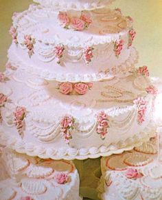 three tiered wedding cake with pink roses on it