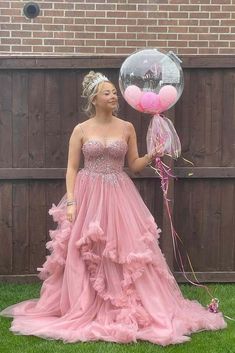 a woman in a pink dress holding a balloon