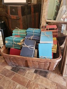 a basket filled with books sitting on top of a tiled floor next to a mirror