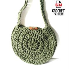 a crochet purse with an orange button on the front and bottom, hanging from a hook