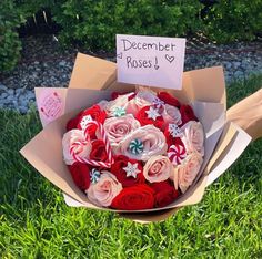 a bouquet of roses in a cardboard box with a sign on it that says december poses