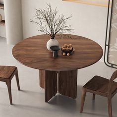 a round wooden table with two chairs and a vase filled with flowers on top of it