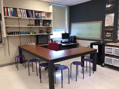 a classroom with desks, chairs and bookshelves filled with books on shelves