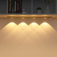 the lights are on above the bookshelf in the room