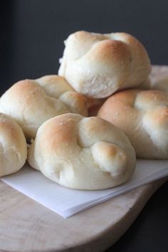 rolls are piled on top of each other on a cutting board