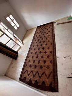 an area rug is on the ground in front of a window and stairs leading up to it