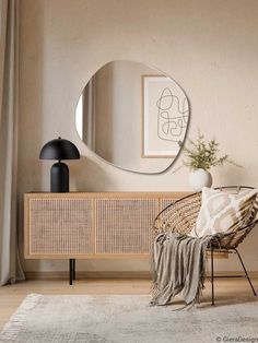 a living room with a round mirror on the wall next to a rattan chair