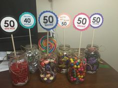 there are many candies in jars on the table with stickers that say 50 cents