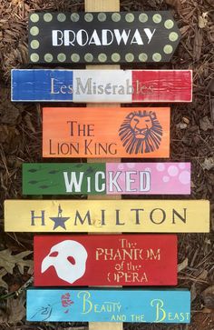 a wooden sign that says broadway, the lion king, the wicked and hamleton