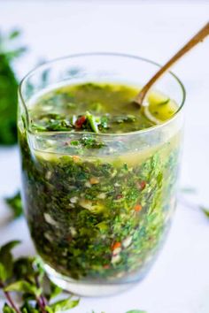 a glass filled with green liquid and vegetables