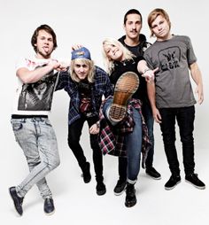 a group of young people standing next to each other posing for a photo with a guitar