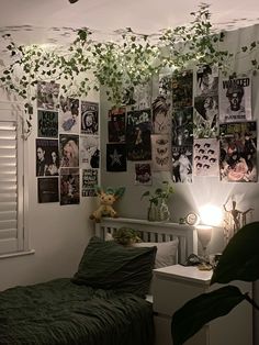 a bedroom with plants hanging from the ceiling and pictures on the wall above it, along with a bed