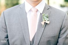 a man in a suit and tie with a boutonniere on his lapel