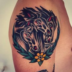 a close up of a tattoo on a person's arm with three horses in the middle