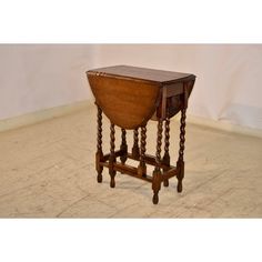 an old wooden table with two legs and a drawer on the top, sitting on a tile floor