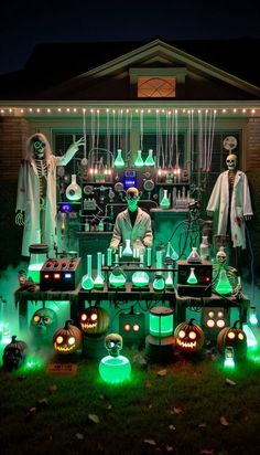 an outdoor halloween display with green lights and decorations on the front lawn at night time