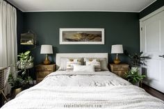 a bedroom with green walls and white bedding