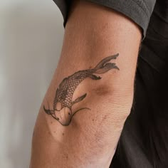 a man with a tattoo on his arm has a koi fish design on it