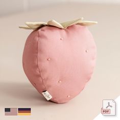 a pink strawberry shaped pillow sitting on top of a table