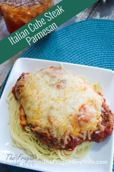 a white plate topped with spaghetti and meat covered in sauce next to a mason jar