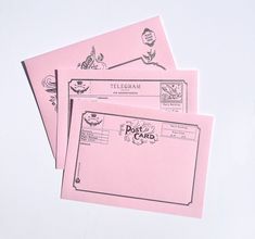 three pink envelopes with designs on them